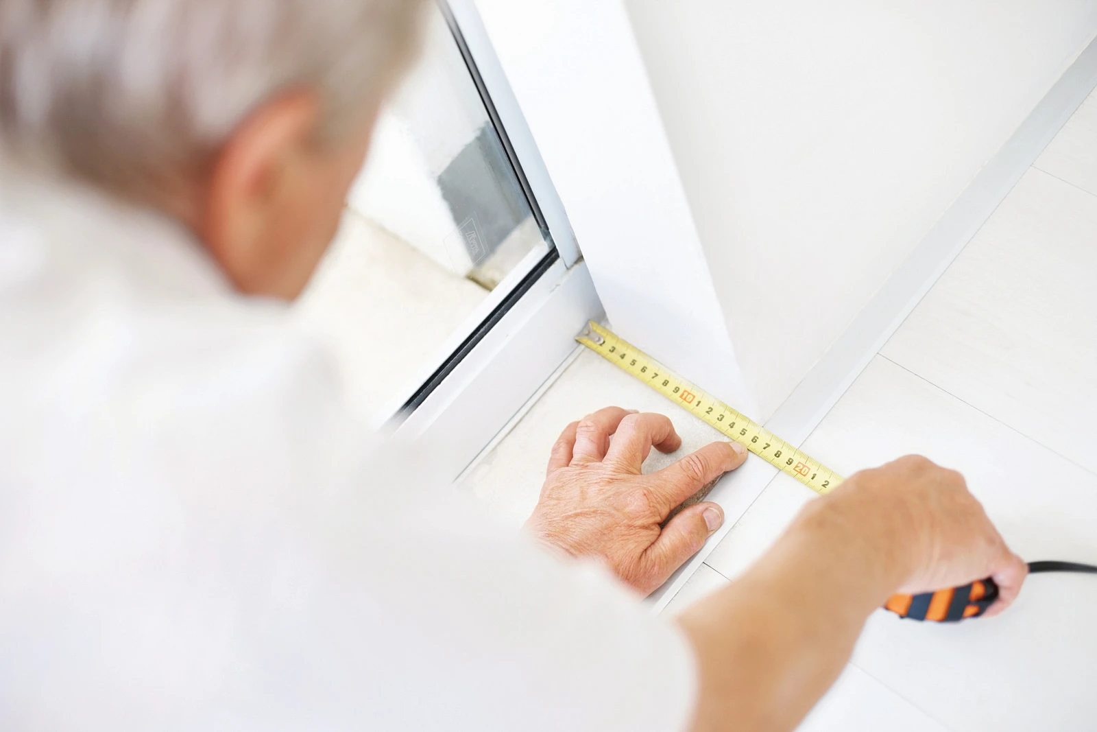 In-home specialist measuring a window opening